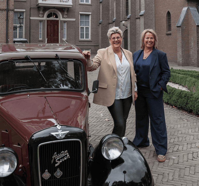 De twee eigenaressen van Label Trends Fashion & Bodywear bij een klassieke Austin Seven voor het oude klooster in Denekamp