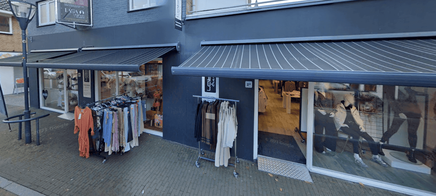 De winkelgevel van Label Trends Fashion & Bodywear met kledingrekken aan de straat in Denekamp